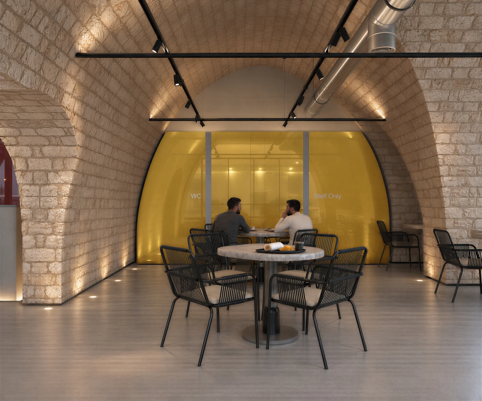 Dining area with a muted yellow backpainted-glass wall beneath the stone arch
